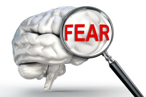 fear word on magnifying glass and human brain